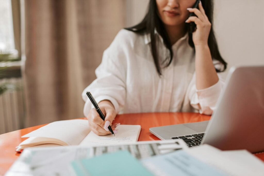 woman on phone taking notes researching how to choose a home care agency in Arizona