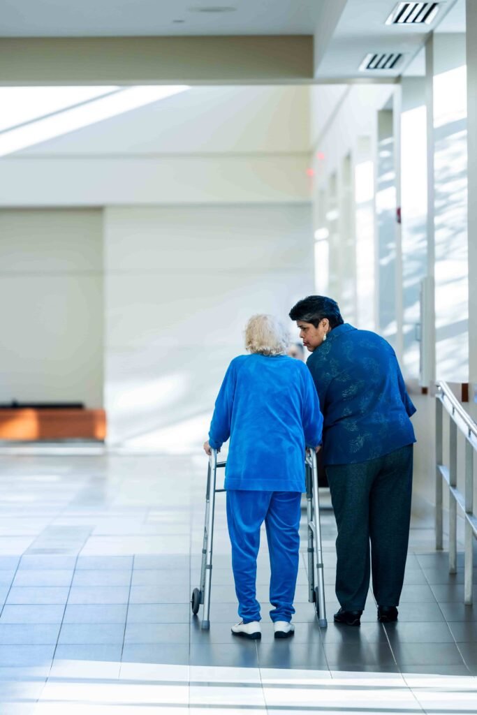 elderly arizona woman and a caregiver walking in assisted living facility
